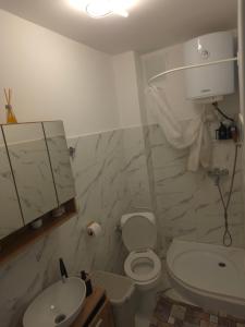 a bathroom with a white toilet and a sink at Apartament Severin Caple in Drobeta-Turnu Severin +6 photos