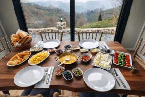 a table with plates of food on it with a view at paradise valley bungalow in Ardeşen