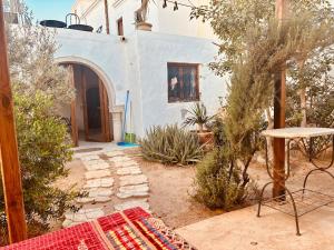 a garden with a table and a building at Hoûch Les Anartistes in Erriadh