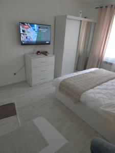 a bedroom with a bed and a flat screen tv at Apartament Severin Caple in Drobeta-Turnu Severin