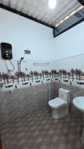 a bathroom with a toilet and trees on the wall at Akshayaam Villa in Kotagala +30 photos