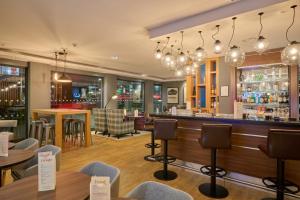 a bar in a restaurant with tables and chairs at Premier Inn Stuttgart Airport Messe in Leinfelden-Echterdingen
