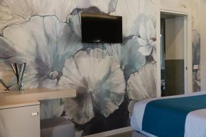 a bedroom with a wall mural of flowers at Gio Leo Guest House in Lesa