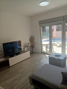 a living room with a tv and a sliding glass door at Vila Komfor in Jajinci