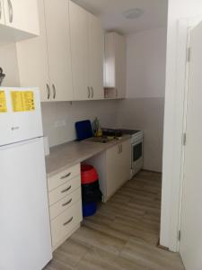 a kitchen with white cabinets and a white refrigerator at Vila Komfor in Jajinci