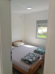 a small bedroom with a bed and a window at Vila Komfor in Jajinci +16 photos