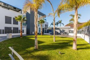 a group of palm trees in front of a building at A&N Sun Terrace Penthouse Caleta Marina in Caleta De Velez