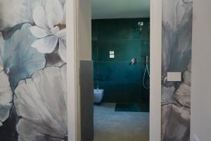 a bathroom with a large flower painted on the wall at Gio Leo Guest House in Lesa +56 photos