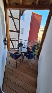 a balcony with a glass table and chairs on it at Ferienwohnung Heike "Zum Spatzennest" in Mühlhausen