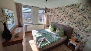 a bedroom with a bed with a flower patterned wall at Ferienwohnung Heike "Zum Spatzennest" in Mühlhausen