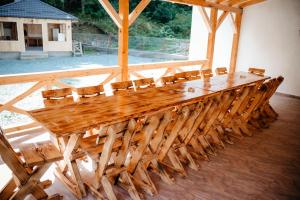 a long wooden table and chairs in a room at Armonia -Rucar in Podu Dîmboviţei
