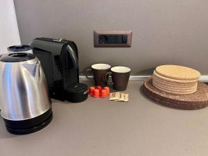 a kitchen counter with a coffee maker and coffee cups at Vicolo Doria Apartment in Rome