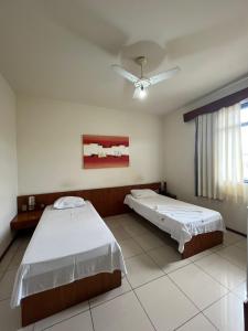 a bedroom with two beds and a ceiling fan at Hotel Muller in Mariana