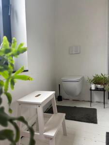 a white bathroom with a toilet and a stool at Maison LE 2 in Solre-le-Château +6 photos