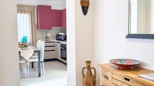 a kitchen and a dining room with red cabinets at Imperial Golden Suite by Ca-Sa Check in Chioggia