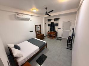 a bedroom with a bed and a room with a fan at Diving Nest in Trincomalee