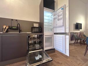 a kitchen with an open dishwasher and an open refrigerator at Vicolo Doria Apartment in Rome