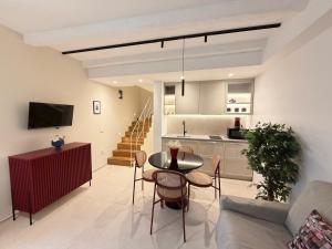 a living room and kitchen with a table and chairs at Fourteensuitetropea in Tropea