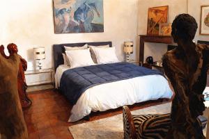 a bedroom with a bed with a blue blanket at Ô Anges in Arles