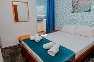 a bedroom with a bed with towels on it at San Georgio Hotel in Tsoutsouros