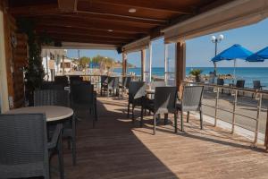 a restaurant with tables and chairs on the beach at San Georgio Hotel in Tsoutsouros