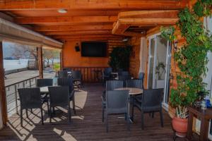 a screened porch with tables and chairs and a television at San Georgio Hotel in Tsoutsouros