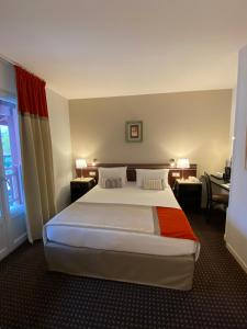 a bedroom with a large bed in a hotel room at Hôtel Ursula in Cambo-les-Bains