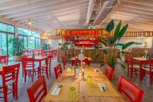 a restaurant with wooden tables and red chairs at Glamping Elba in SantʼAnna