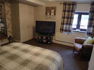 a bedroom with a bed and a flat screen tv at Heskin Farm in Burscough