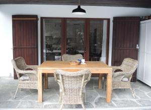 a wooden table with wicker chairs on a patio at Casa Hella by fewotessin in Lavertezzo