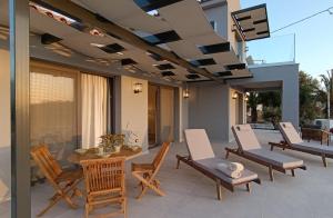 a patio with chairs and a table and a television at Villa GEIA in Klísmata
