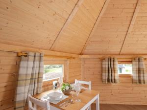 a wooden dining room with a table in a cabin at Little Luxe Lodges 1 in Kyle of Lochalsh