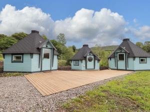 two houses with a wooden deck in a field at Little Luxe Lodges 1 in Kyle of Lochalsh