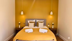 a bedroom with a yellow bed with two white pillows at Domaine de Treuillaud in Villers-les-Ormes