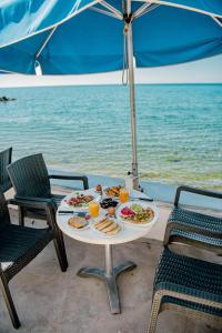 a table with two plates of food and orange juice at San Georgio Hotel in Tsoutsouros