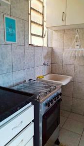 a kitchen with a stove and a sink at Praticidade e conforto á poucos passos do aereoporto in Várzea Grande +28 photos