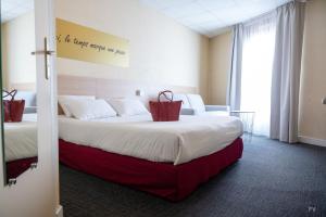a hotel room with two beds with red bags on the bed at Hotel Kyriad Lamballe in Lamballe +47 photos