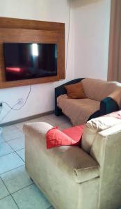 a living room with a couch and a flat screen tv at Praticidade e conforto á poucos passos do aereoporto in Várzea Grande