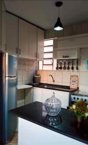 a kitchen with white cabinets and a black counter top at Praticidade e conforto á poucos passos do aereoporto in Várzea Grande