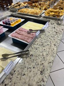 a counter with different types of desserts and pastries at Hotel Muller in Mariana +22 photos