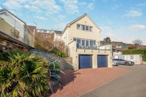 a large white house with a blue garage at 4 Bed in Newquay oc-b27906 in Newquay