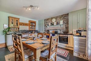 a kitchen with a wooden table and some chairs at 3 Bed in Uphill oc-n27747 in Linkinhorne