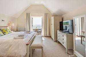 a bedroom with a large bed and a television at 2 Bed in Croyde oc-r27591 in Croyde
