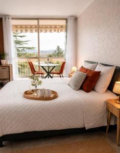 a bedroom with a bed with a table and a window at Charmant Studio, 2 personnes, 25 minutes du Zoo de Beauval in Montrichard