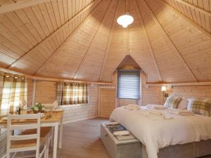 a bedroom with a large bed in a wooden cabin at Little Luxe Lodges 2 in Balmacara