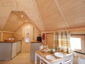 a kitchen and dining room with a table in a cabin at Little Luxe Lodges 2 in Balmacara