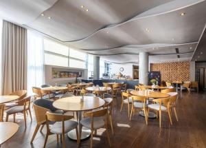 a dining room with wooden tables and chairs at Nobel Zira Hotel in Belgrade