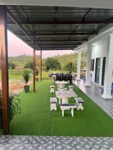 a group of picnic tables and chairs on grass at Villa Cempaka Homestay in Changlun