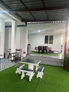 a patio with a ping pong table and benches at Villa Cempaka Homestay in Changlun