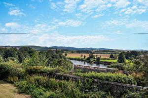 a train traveling through a field with a river at 2 Bed in Coldstream oc-t30042 in Coldstream